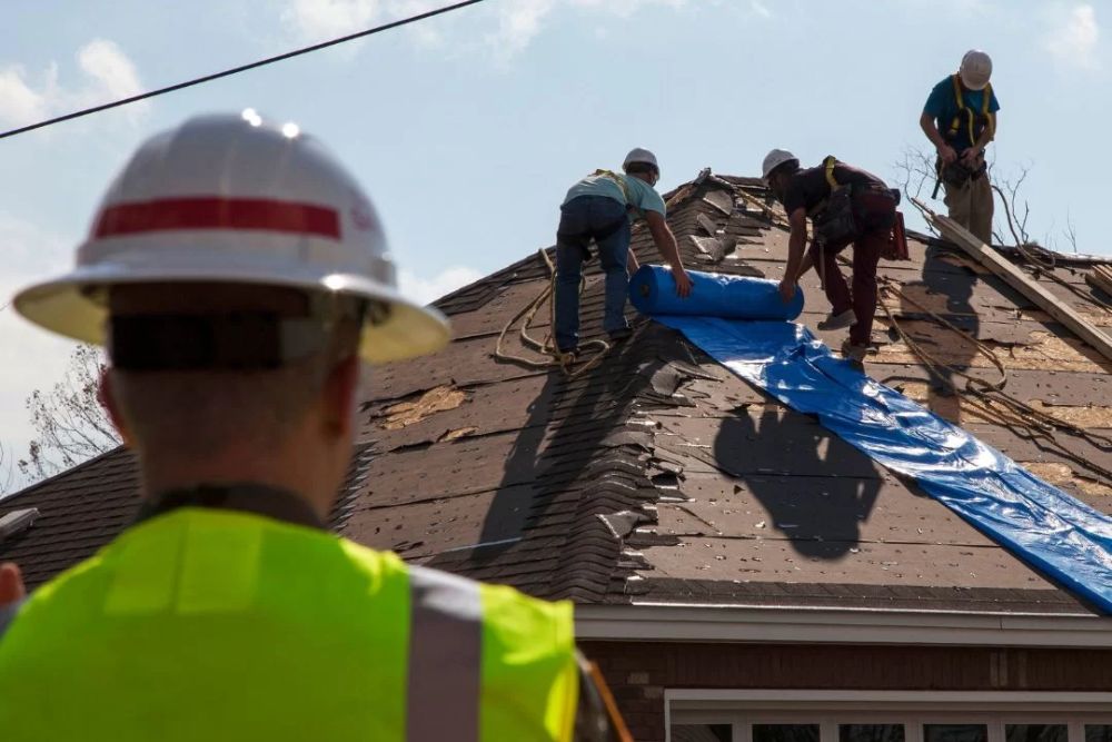 Men collaborating on a roof replacement in San Antonio, demonstrating professionalism and expertise in roofing services.